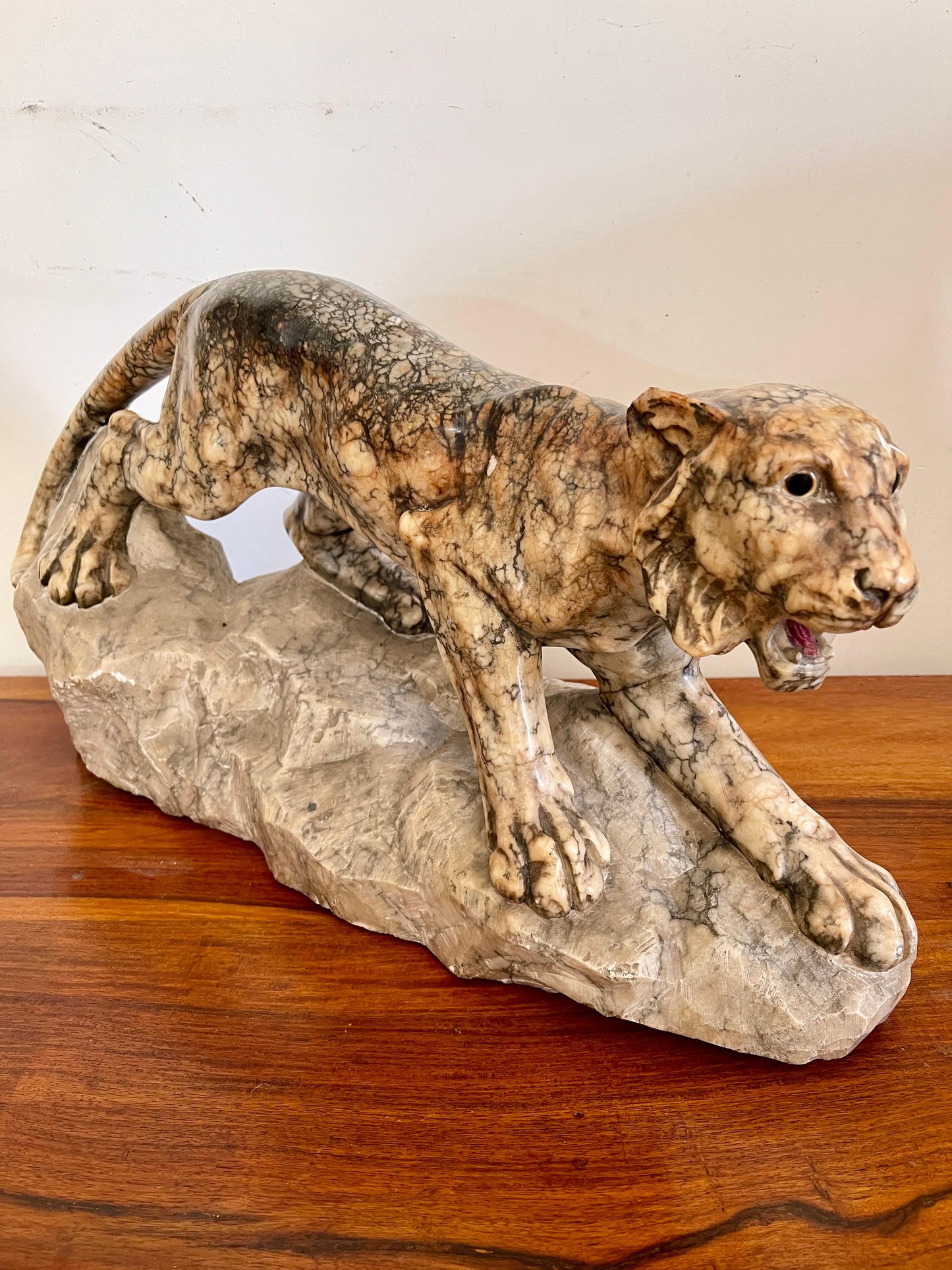 Scultura in marmo di pantera in posizione d'attacco su roccia, XX secolo