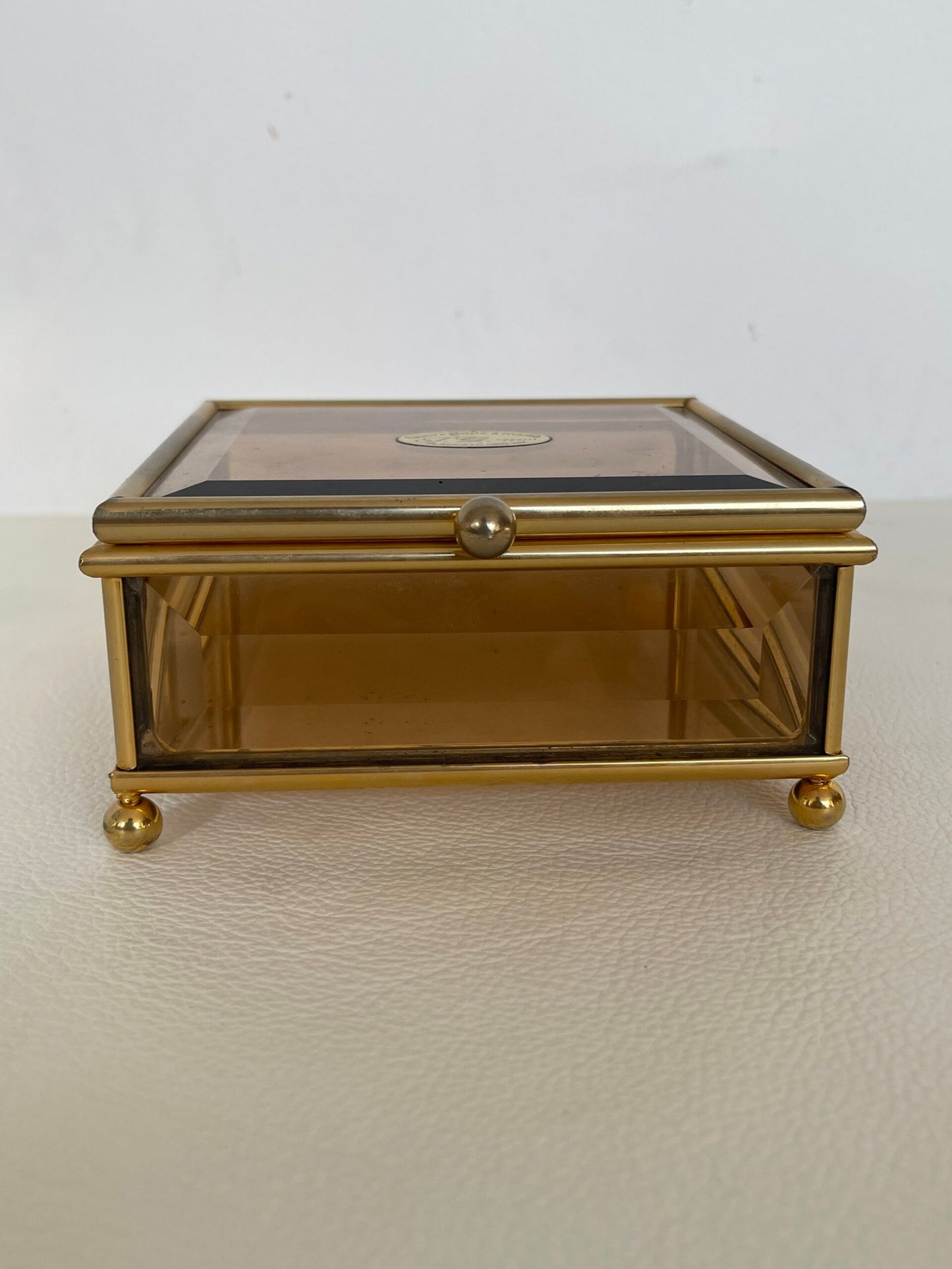 Raffinata scatola in ottone dorato con un delicato vetro fumé