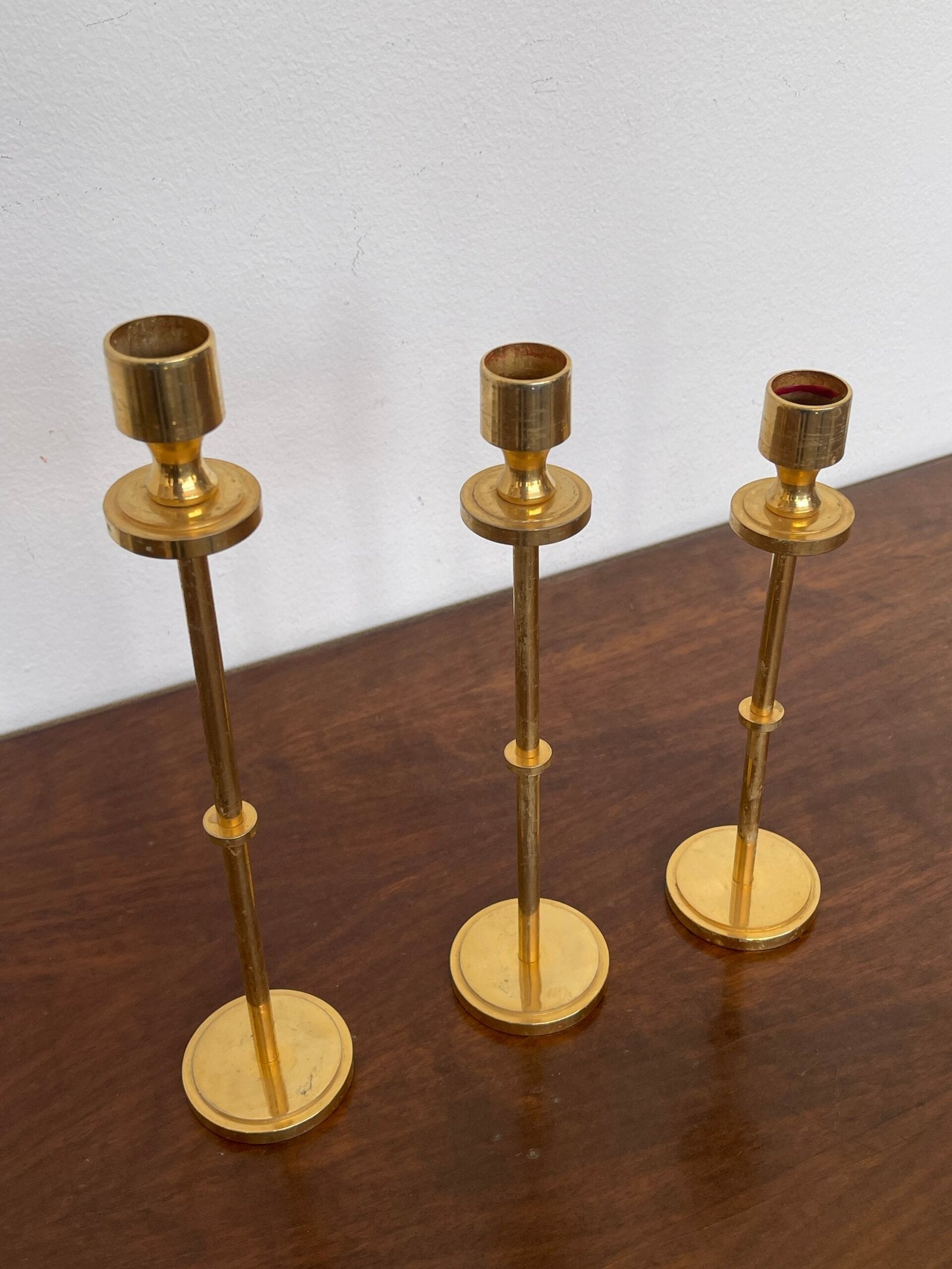 Tris di portacandele modernisti in ottone lucido, dal design minimalista ed elegante.