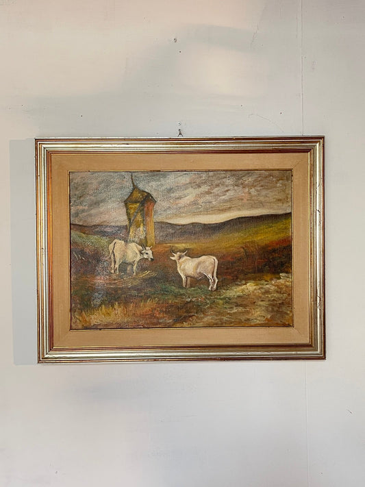 Quadro vintage dipinto ad olio su tela, raffigurante una suggestiva scena rurale con due mucche al pascolo in un paesaggio collinare.