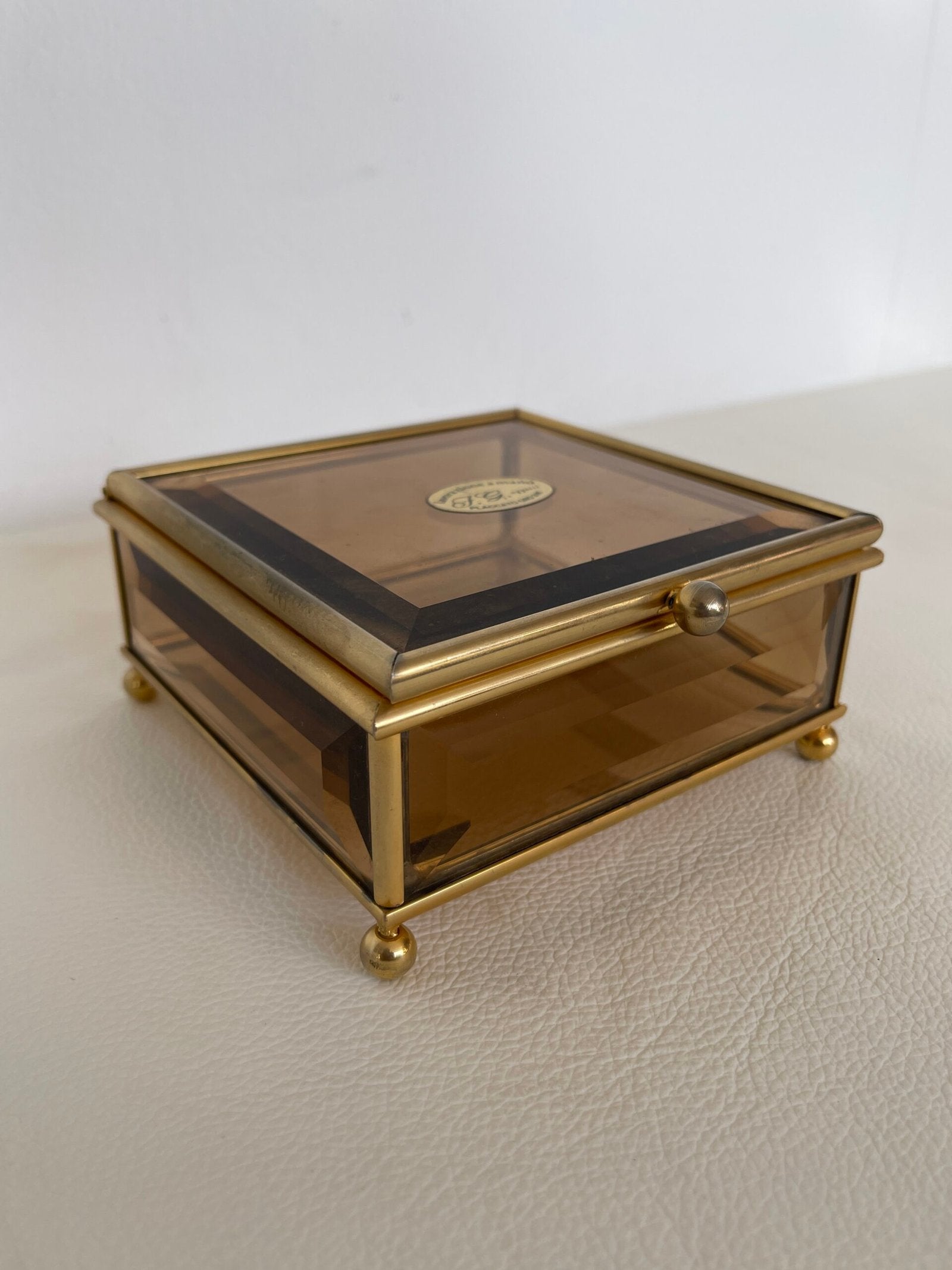 Raffinata scatola in ottone dorato con un delicato vetro fumé