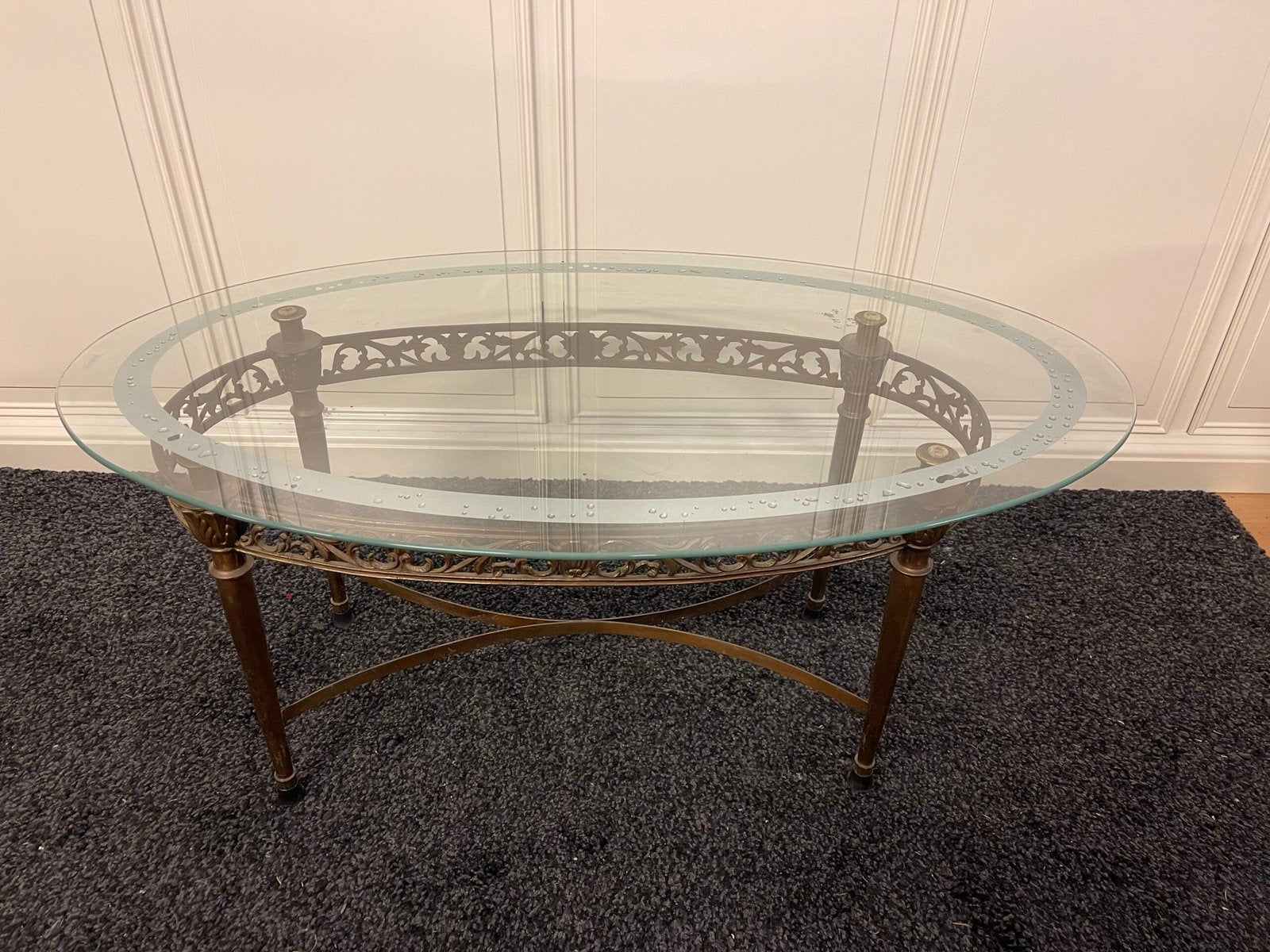 Tavolino da salotto ovale con piano in vetro e struttura in ferro battuto