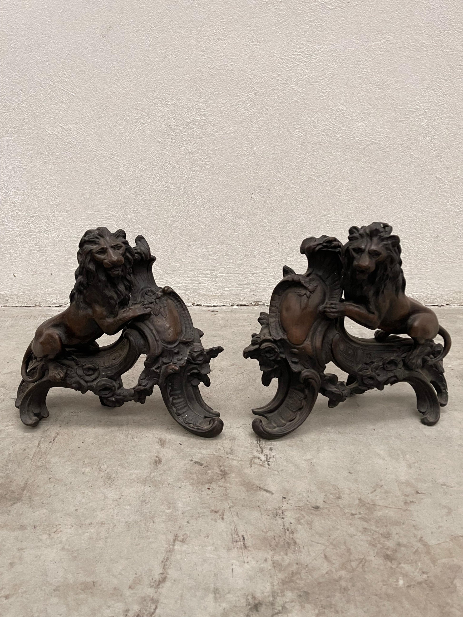 Chenet en forme de lion surmontant un écusson bronze