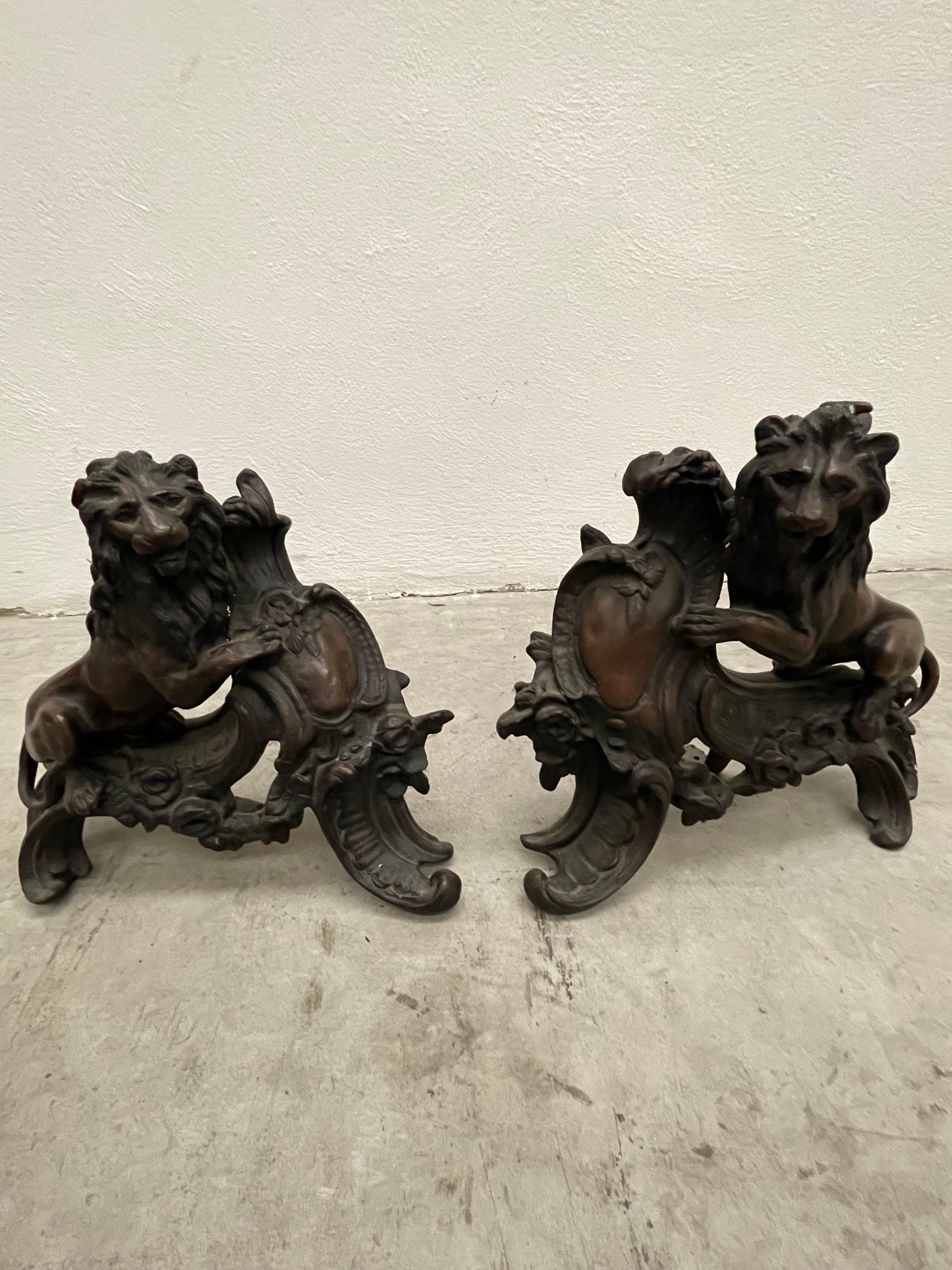 Chenet en forme de lion surmontant un écusson bronze