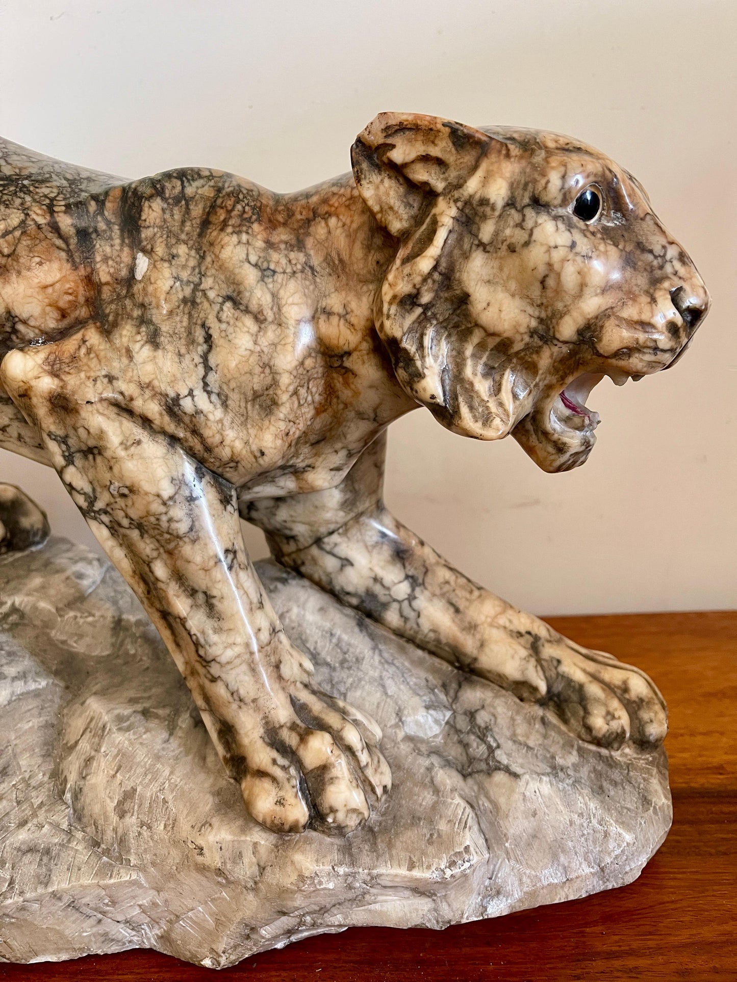 Scultura in marmo di pantera in posizione d'attacco su roccia, XX secolo