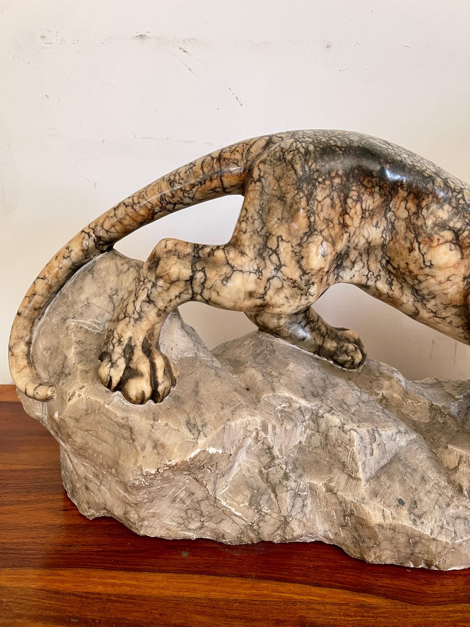 Scultura in marmo di pantera in posizione d'attacco su roccia, XX secolo