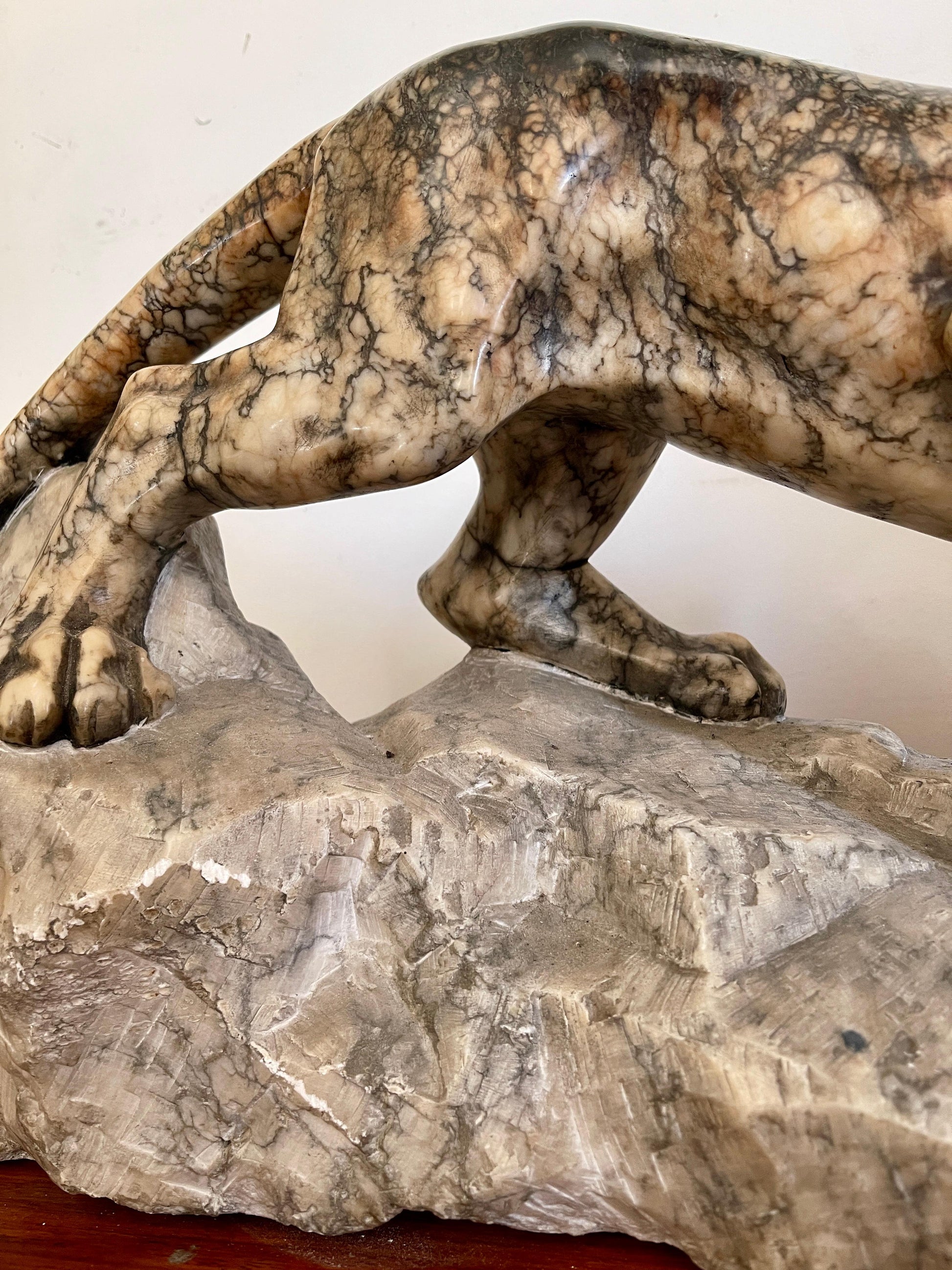 Scultura in marmo di pantera in posizione d'attacco su roccia, XX secolo