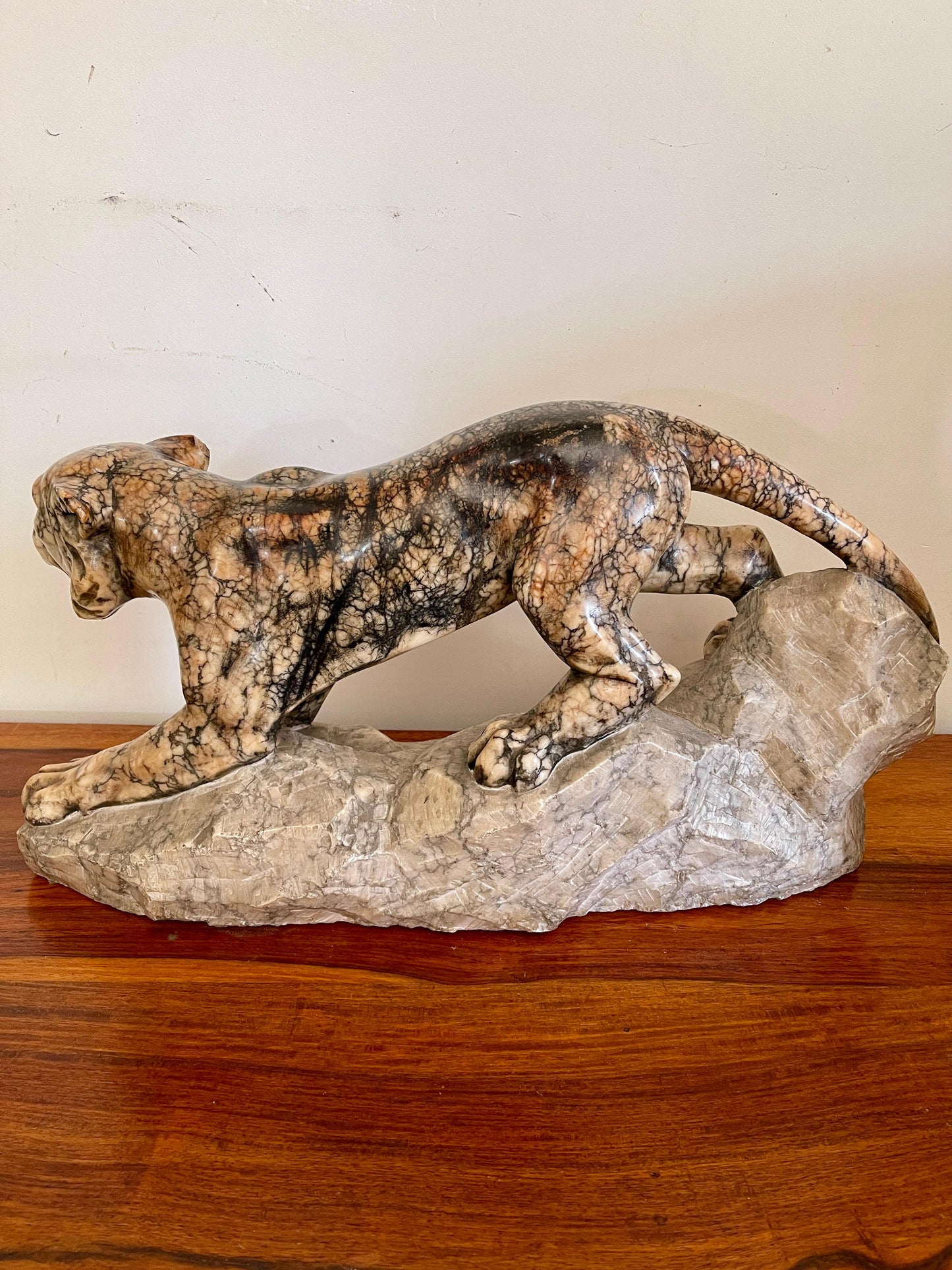 Scultura in marmo di pantera in posizione d'attacco su roccia, XX secolo