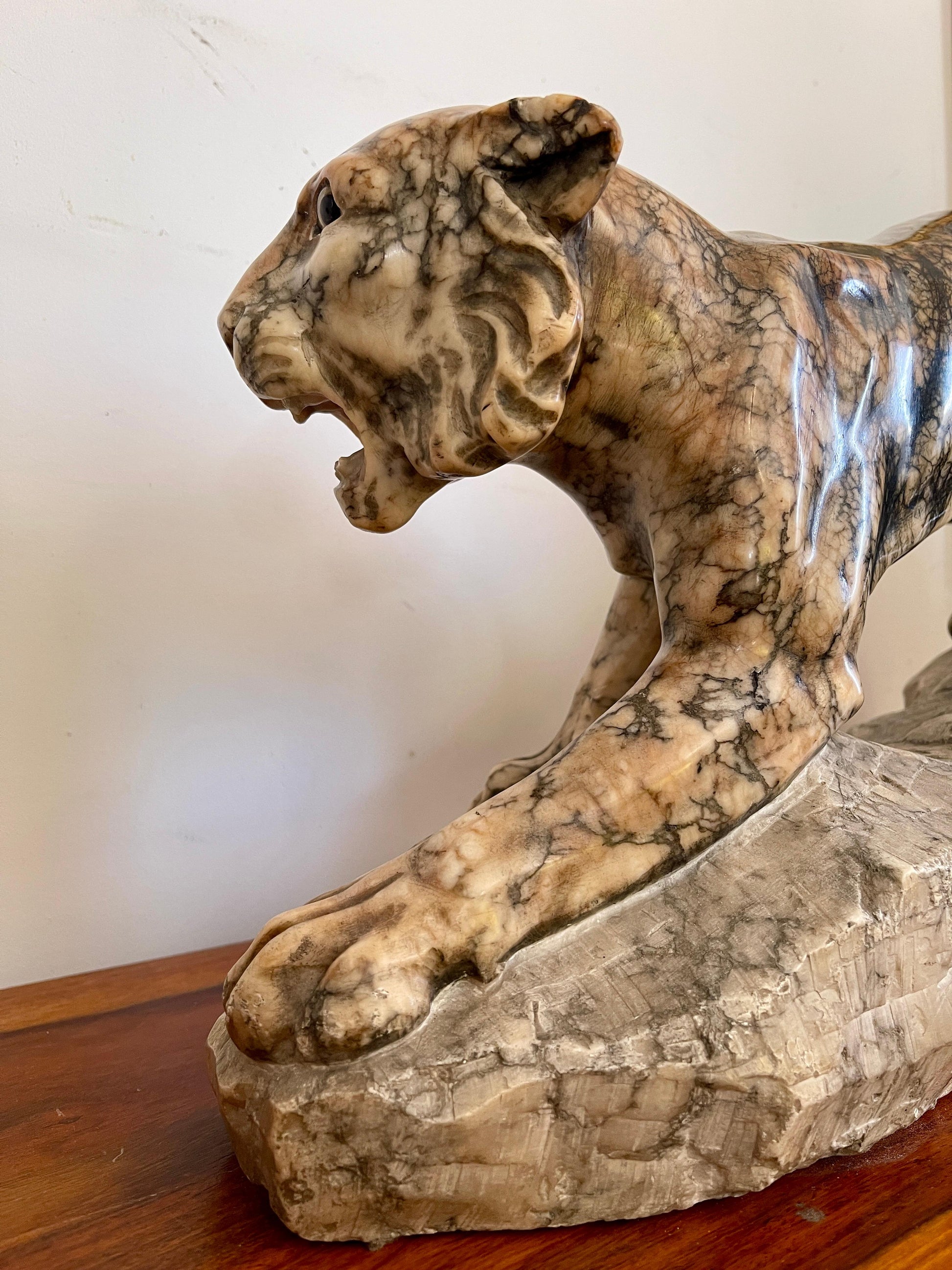 Scultura in marmo di pantera in posizione d'attacco su roccia, XX secolo