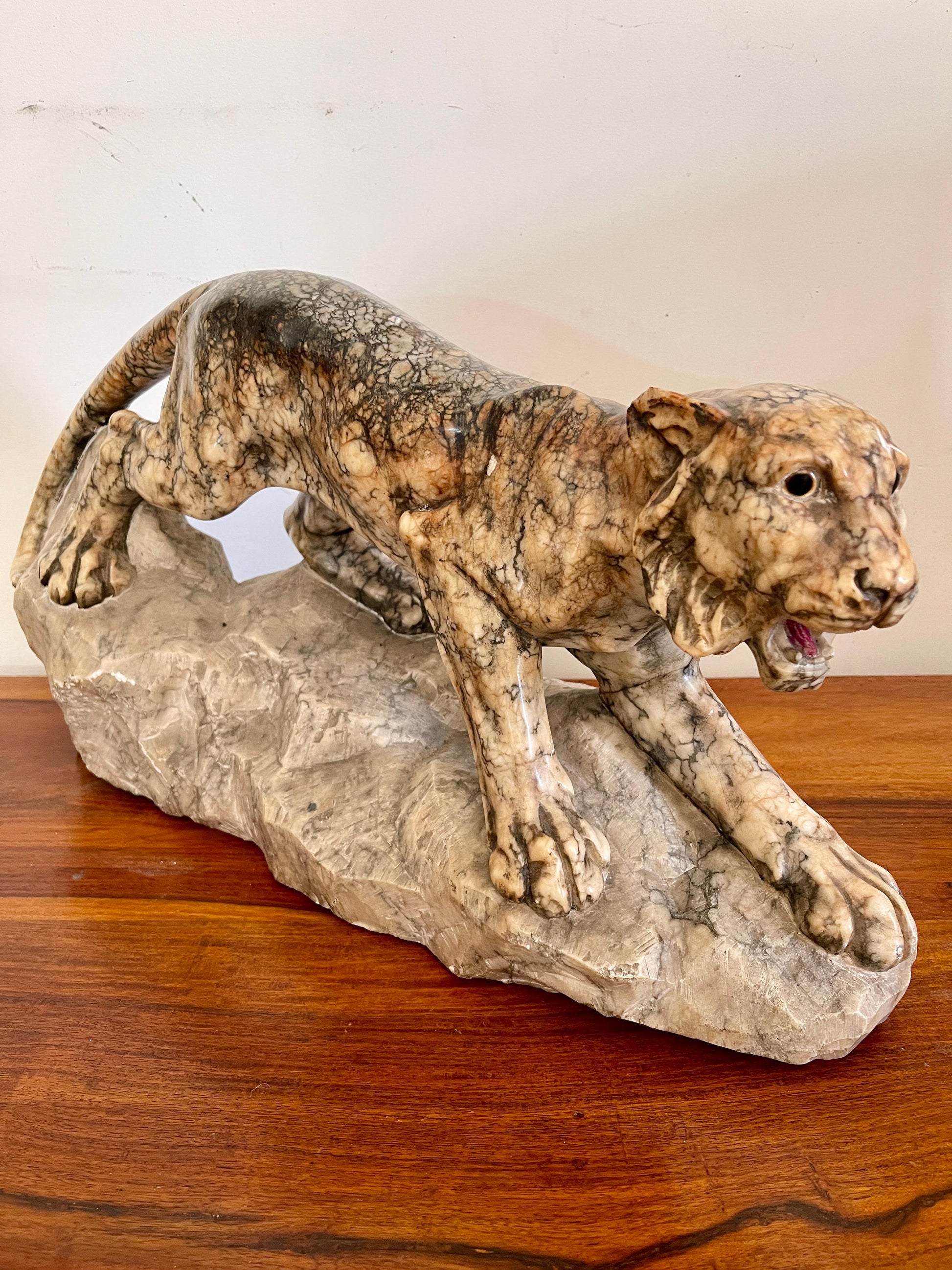 Scultura in marmo di pantera in posizione d'attacco su roccia, XX secolo