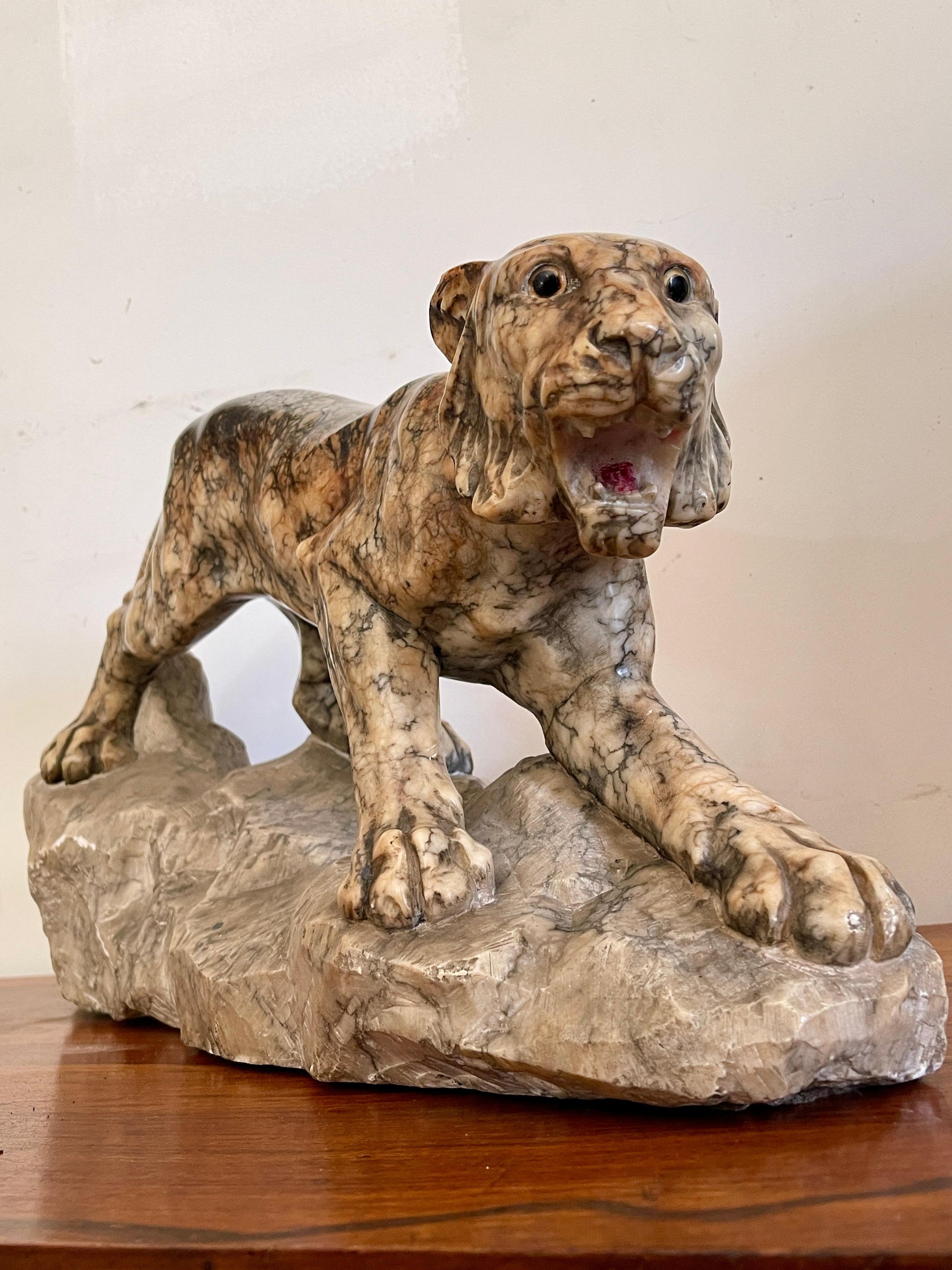 Scultura in marmo di pantera in posizione d'attacco su roccia, XX secolo