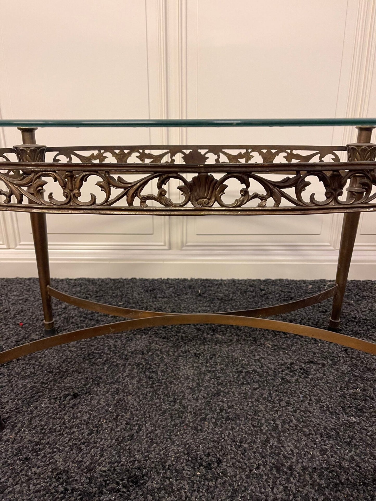 Tavolino da salotto ovale con piano in vetro e struttura in ferro battuto