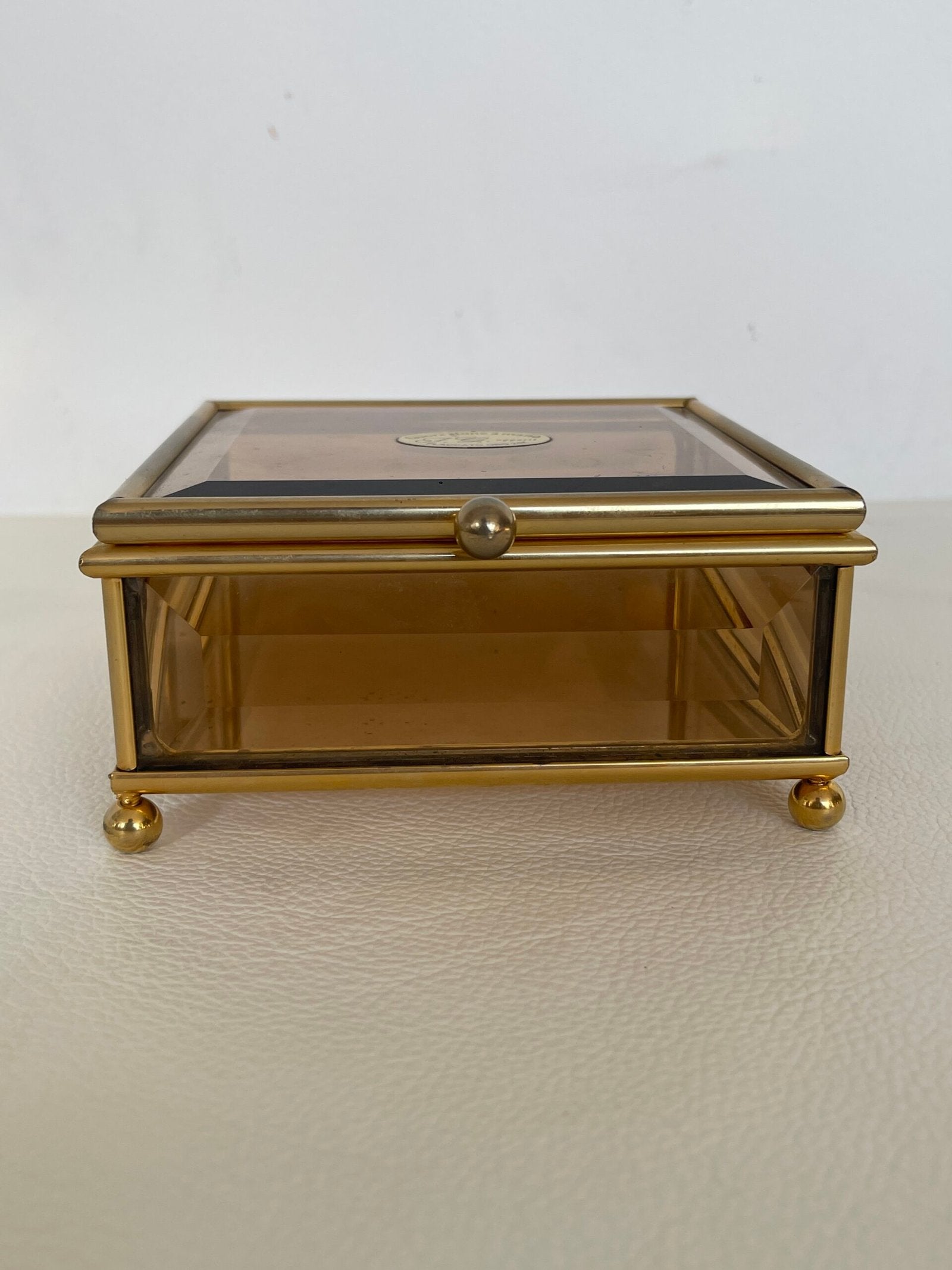 Raffinata scatola in ottone dorato con un delicato vetro fumé