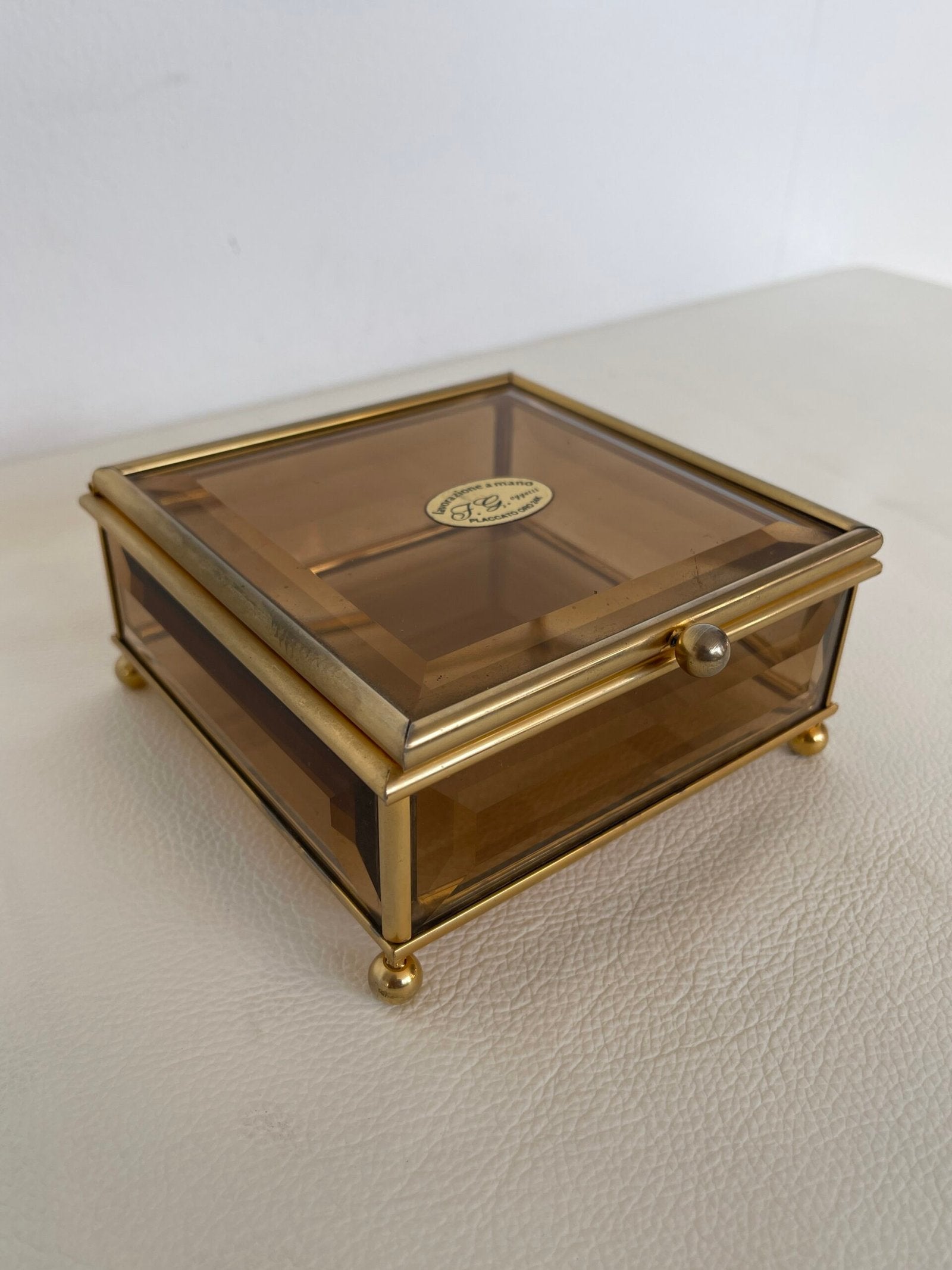 Raffinata scatola in ottone dorato con un delicato vetro fumé