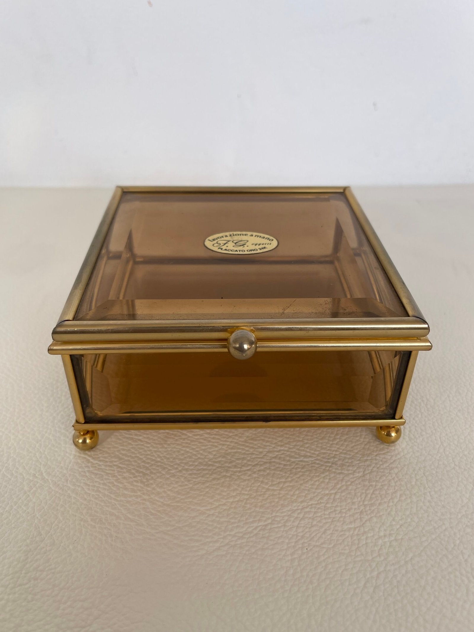 Raffinata scatola in ottone dorato con un delicato vetro fumé