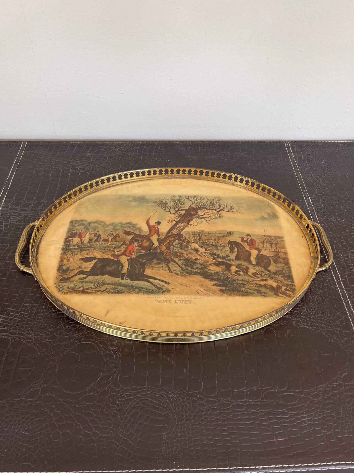 Vassoio ovale in metallo dorato è un pezzo unico che cattura l’essenza della tradizione e del fascino vintage.