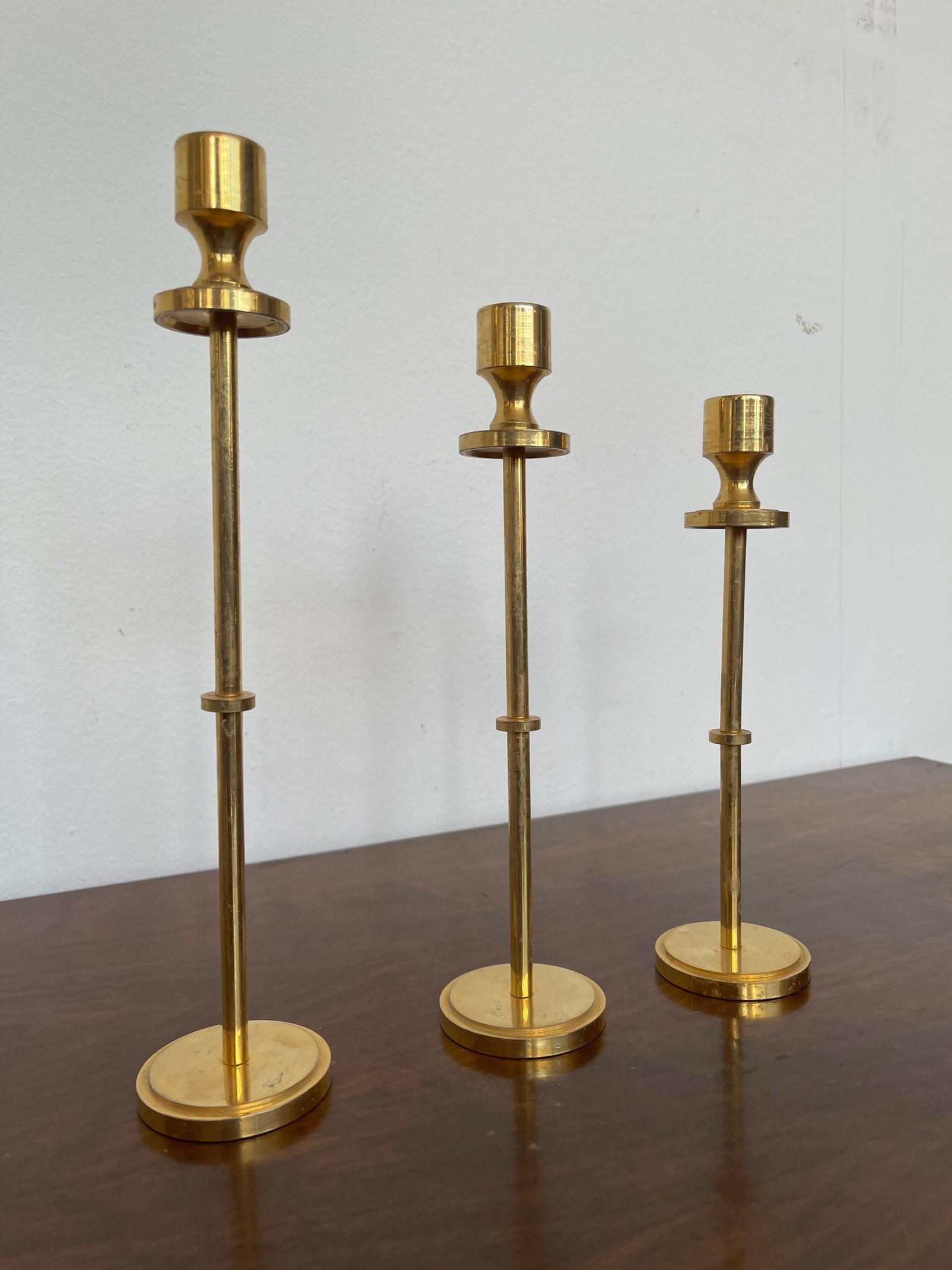 Tris di portacandele modernisti in ottone lucido, dal design minimalista ed elegante.